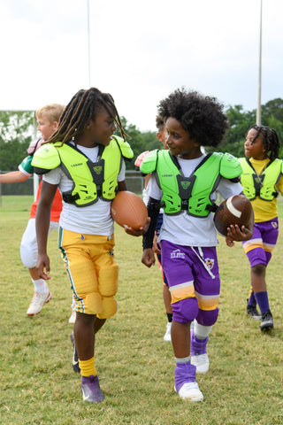 Two boys in LEGION M-80 Youth Highlight Football Shoulder Pads and football uniforms