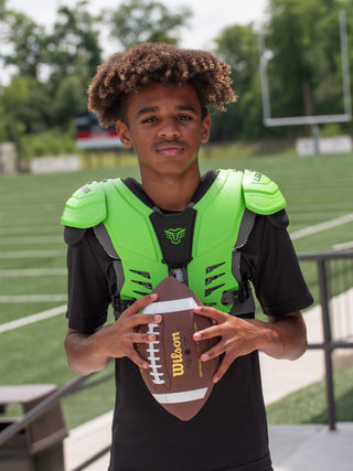 Person holding a Wilson football on a sports field
