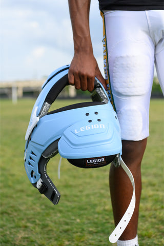 LEGION M-80 Youth University Football Shoulder Pads in light blue, held by a player