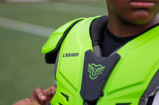 Close up of a person wearing a bright green Legion shoulder pad with a black logo