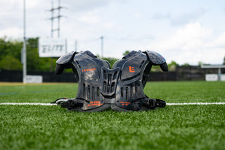 LEGION M-250 Varsity Football Shoulder Pads on a green football field