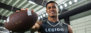 Man in a grey Legion shirt holding a football