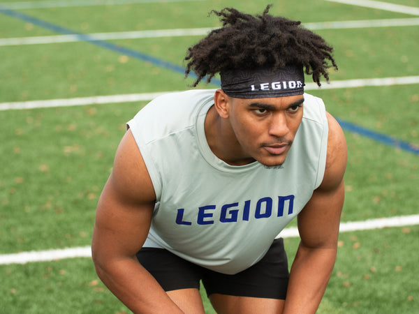Athlete wearing a Legion brand headband and sleeveless shirt on a sports field